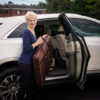 A woman holding her purse in the back of a car.